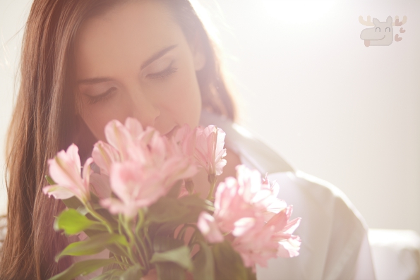 Portrait of lovely lady looking at flowers and smelling them